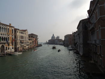 Canal amidst buildings against sky