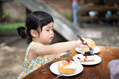 Midsection of woman with ice cream on table