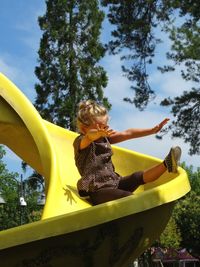 Low angle view of girl on slide at playground