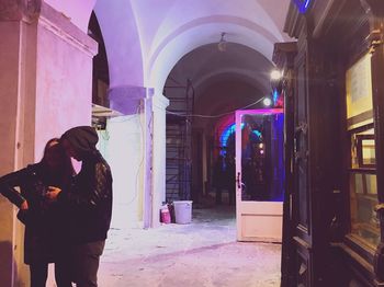 Rear view of woman standing at entrance of building