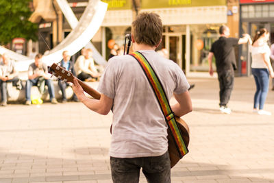 Rear view of men walking on city street