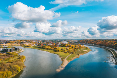 Aerial view of river flowing through city against sky