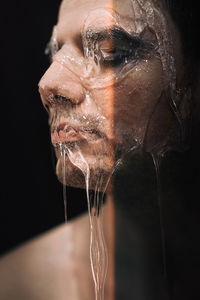 Close-up of gel on man face in darkroom