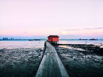 Pier over sea against sky during sunset