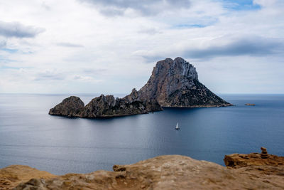 Rock formation in sea against sky