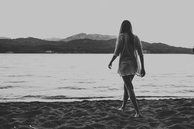 Rear view of woman walking on beach