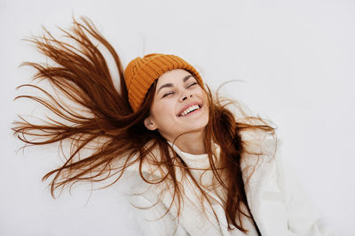 Portrait of smiling young woman against white background