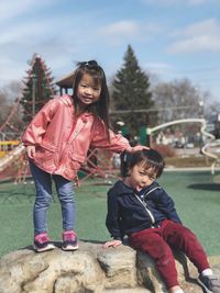 Portrait of siblings playing at playground