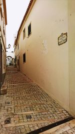 Empty alley amidst buildings in city