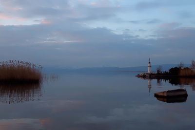 Scenic view of sea against cloudy sky at dusk