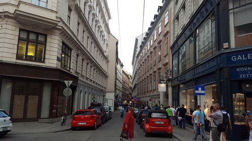 Cars on road in city against sky