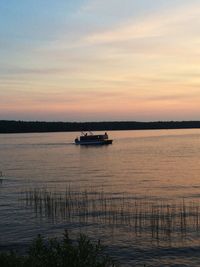 Boats in sea at sunset