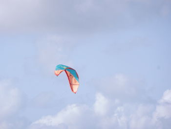 Low angle view of person paragliding against sky