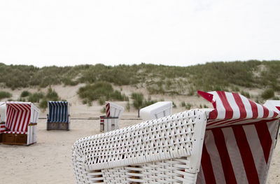 The photo shows some beach chairs on the north sea island baltrum with cloudy sky