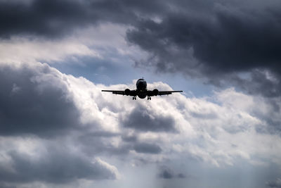 Low angle view of airplane flying against sky