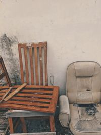 Empty chairs and table against wall