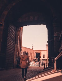 Rear view of people walking on street in city