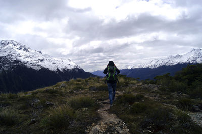 Rear view of a woman on landscape against mountain range