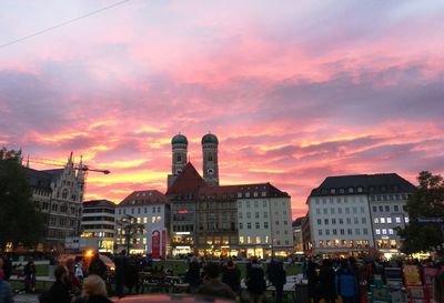 People in city against sky during sunset