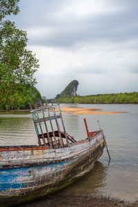 Boat moored on river against sky