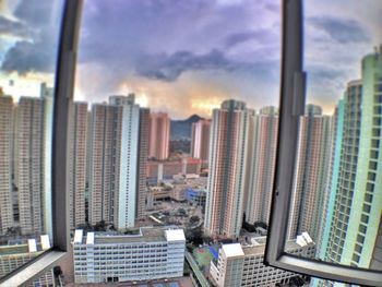 View of cityscape against cloudy sky