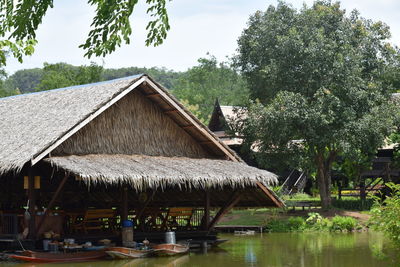 Built structure by trees and building against sky