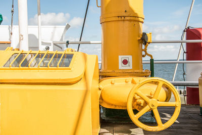 Close-up of yellow ship in sea against sky