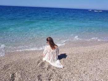 Woman at beach against sky