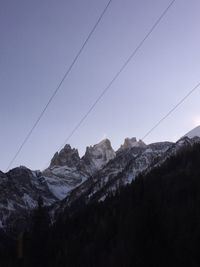 Low angle view of snowcapped mountains against clear sky