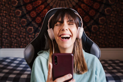 Smiling young woman video conferencing over mobile phone