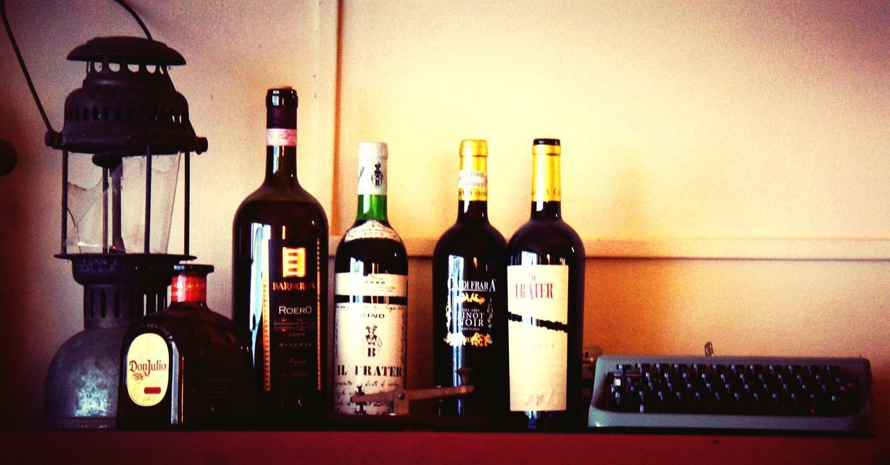 CLOSE-UP OF WINE BOTTLES IN SHELF