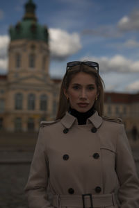 Portrait of young woman standing against sky