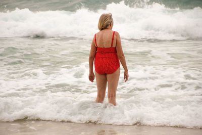 Rear view of man walking on beach