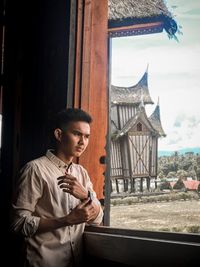 Young man looking through window