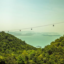 Low angle view of overhead cable car against sky