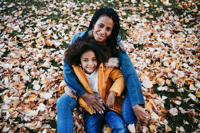Portrait of a smiling young woman with autumn leaves