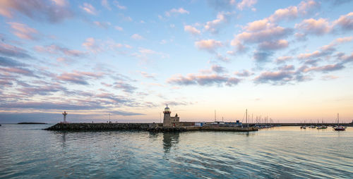 Scenic view of sea against cloudy sky during sunset