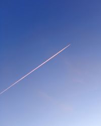 Low angle view of vapor trail in blue sky