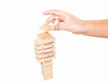 Close-up of hand holding stack against white background