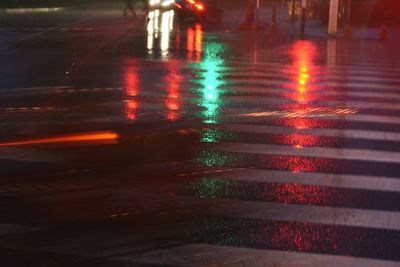 Reflection of illuminated buildings in puddle