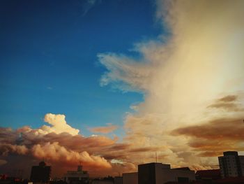 Low angle view of cityscape against blue sky