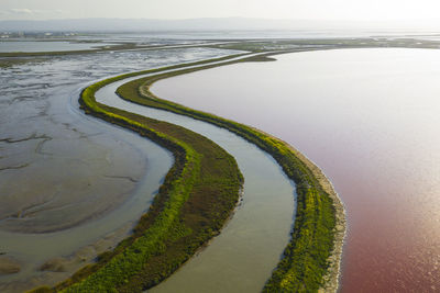 Multi colored water in ponds and stream in salt marsh in sf bay aerial