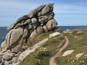 Rock formation on beach against sky