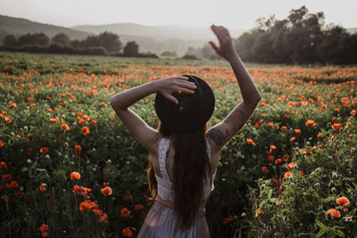 Rear view of woman standing on field