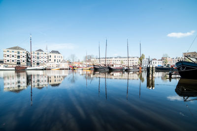 Boats moored at harbor against buildings