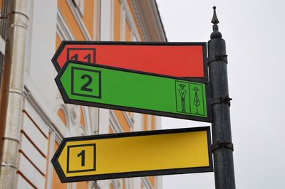 Low angle view of road sign against built structure