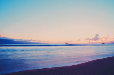View of calm beach against blue sky