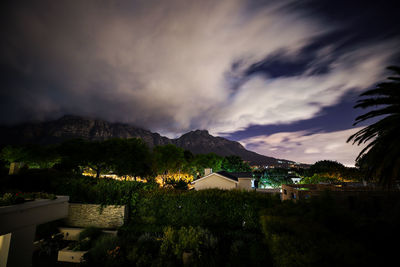 Houses and buildings against sky at night