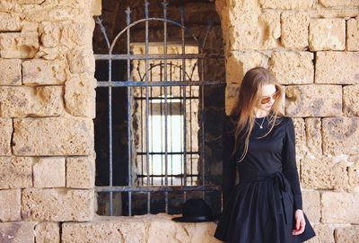 Young woman standing against window