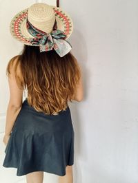 Rear view of woman standing against wall